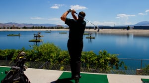 Photo of man complete gold swing at Grand Bay Driving Range.